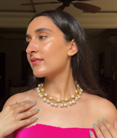 Woman wearing a pearl necklace with a blurred indoor background